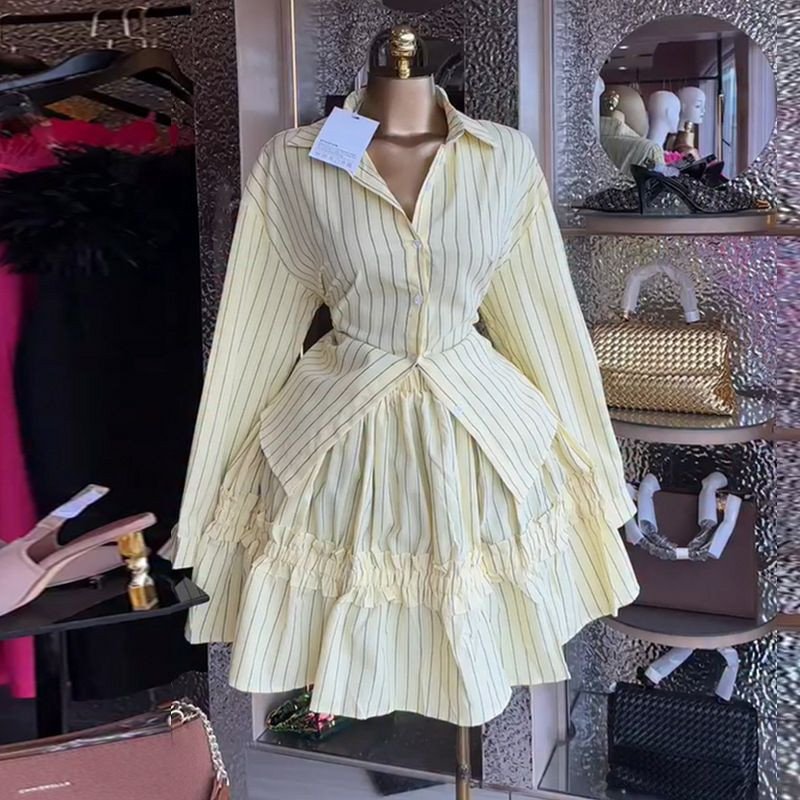 Ensemble deux pièces jaune à fines rayures se compose d'une chemise à manches longues avec un basque structuré et d'une jupe évasée à volant